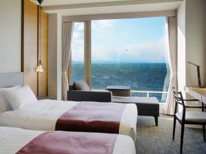 a hotel room with two beds and a view of the ocean at Lake Saroma Tsuruga Resort in Kitami