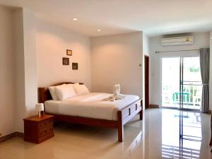 a bedroom with a bed and a large window at Baan Yokmhanee in Hua Hin