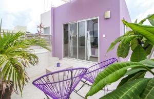 a purple house with two purple chairs on a balcony at Villas Geminis Boutique Condohotel in Tulum