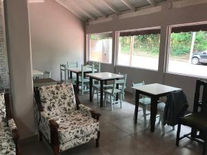 a dining room with tables and chairs and a chair at Hotel Mola in Puerto Iguazú