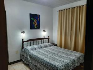 1 dormitorio con 1 cama y 2 luces encendidas en Hotel Mola en Puerto Iguazú