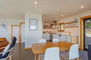 eine Küche und ein Esszimmer mit einem Tisch und Stühlen in der Unterkunft Haulashore Vista in Nelson