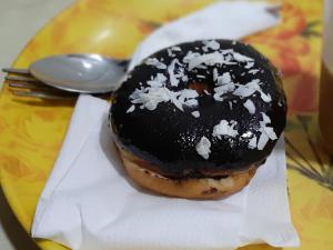 a doughnut on a plate with a fork and a spoon at Hotel Regal Plaza in Mumbai