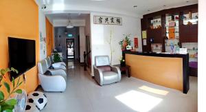 a waiting room at a hospital with chairs and a tv at Yang's B&B in Jinning