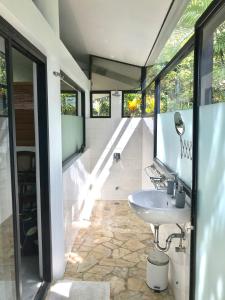 a bathroom with a sink and a large window at Air Manis Hill Residence in Padang
