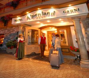 a group of people standing outside of a store with luggage at Hotel Garni Alpenland in Altenmarkt im Pongau