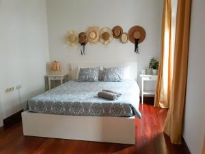 ein Schlafzimmer mit einem Bett in einem Zimmer mit Hüten an der Wand in der Unterkunft Casa 17 in San Sebastián