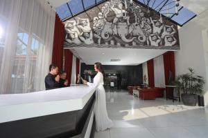 une mariée et un marié debout au comptoir dans un hall dans l'établissement Queenco Hotel & Casino, à Sihanoukville
