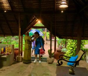 two people standing under a pavilion holding an umbrella at A4 Villa & Spa. in Habarana