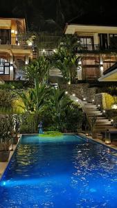 a large blue swimming pool in front of a building at Puri Kasih Gottlieb in Ubud