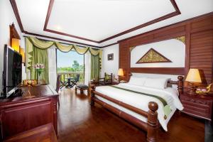 a bedroom with a large bed and a television at Borei Angkor Resort & Spa in Siem Reap