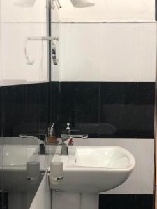 a bathroom with a white sink and a mirror at Jade Green Rest Inn in Ella