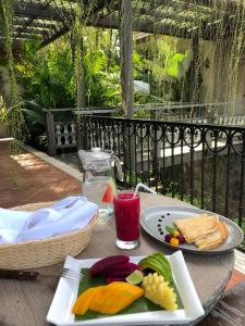 una mesa con dos platos de comida y una bebida en Puri Kasih Gottlieb, en Ubud