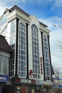 un gran edificio con grandes ventanas en una calle en Estet Hotel, en Yessentuki