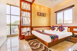 1 dormitorio con 2 camas y ventana en FabHotel The Khushi Regent en Bhopal