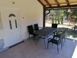 a patio with a table and chairs and a white door at Vikendica na Zlatiboru in Zlatibor