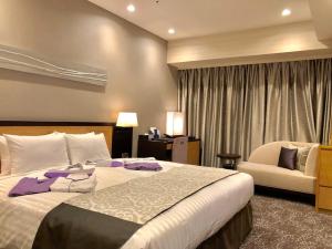 藤枝市にあるホテル オーレの大きなベッドと椅子が備わるホテルルームです。