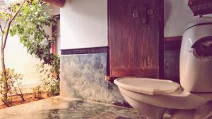 a bathroom with a toilet in a room at Punnamada Resort in Alleppey