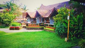 a house with a fence and a yard with green grass at Punnamada Resort in Alleppey