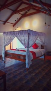 - une chambre avec un lit à baldaquin dans l'établissement Punnamada Resort, à Alappuzha