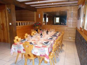 Un comedor con una mesa larga y sillas. en Chalet Jonquille, en Les Gets 25 fotos más