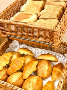 two baskets filled with breads and baskets of pastries at Hotel Arena Rooms - Berlin Mitte in Berlin