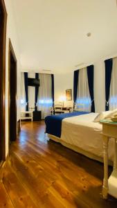 a bedroom with a large bed with blue curtains at Hostal Paris in Valladolid