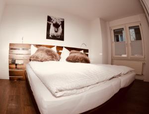 a bedroom with a large white bed with two pillows at Emelie Zermatt 4**** in Zermatt