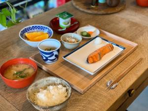 a wooden table with a tray of food on it at Guest House maison de stuffmarket in Takamatsu
