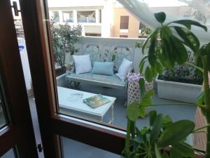 - une terrasse couverte avec un canapé et une table sur un balcon dans l'établissement Airport & Fair Suite Apartments, à Fiumicino