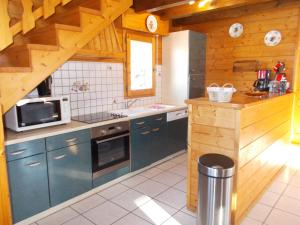 a kitchen with blue cabinets and a microwave at Chalet Jonquille in Les Gets