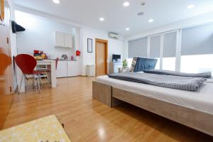 ein Schlafzimmer mit einem großen Bett und einem Schreibtisch in der Unterkunft Apartments Midnight City in Dubrovnik