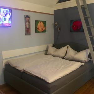 ein Schlafzimmer mit einem Bett mit einer Leiter in der Unterkunft Kleines Haus am Hafen - ruhig und grün am Ortsrand in Prerow