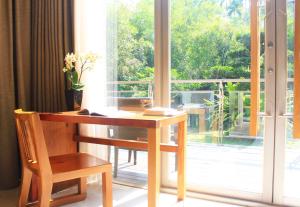 a wooden desk with a chair next to a window at ChooArt B&B in Sanyi