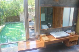 a bathroom with a sink and a swimming pool at ChooArt B&B in Sanyi