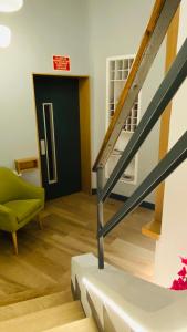 een woonkamer met een trap en een groene stoel bij Hostal Paris in Valladolid