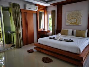 a bedroom with a bed with a doll sitting on it at The Peace Tara House in Ko Lanta