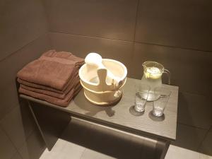 Wellness hotel Harmonie Třeboň في تريبون: حمام مع منضدة مع حوض وكاسات