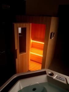 ein Badezimmer mit einer Badewanne mit Licht in der Tür in der Unterkunft Wellness hotel Harmonie Třeboň in Třeboň