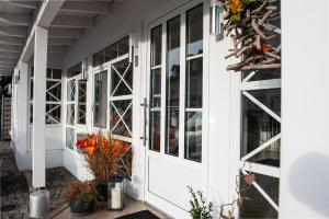 a white front door of a house with plants at Hotel Angermeier GARNI in Eching