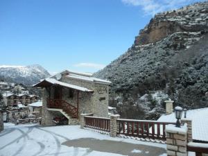 a house with a snow covered balcony in the mountains at Archontiko Zachlorou in Kato Zachlorou