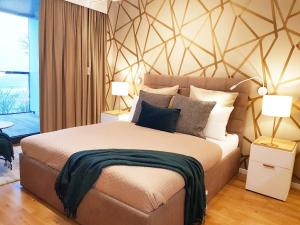 sypialnia z dużym łóżkiem i 2 lampami w obiekcie APARTLUX Seaside Park - bezpośredni widok na morze w Kołobrzegu +19 zdjęć