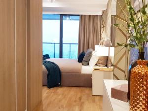 sypialnia z łóżkiem i dużym oknem w obiekcie APARTLUX Seaside Park - bezpośredni widok na morze w Kołobrzegu