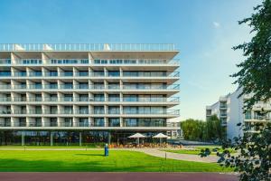 duży budynek z trawnikiem przed nim w obiekcie APARTLUX Seaside Park - bezpośredni widok na morze w Kołobrzegu