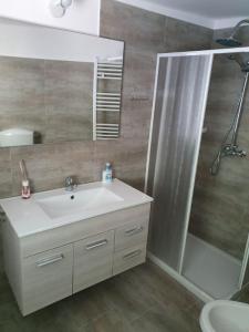 a bathroom with a sink and a shower and a mirror at HAPPY HOUSE MORSANO in Morsano al Tagliano