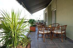 - une terrasse couverte avec une table et des chaises sur un balcon dans l'établissement Stylish Apartment, Acropolis view, à Athènes