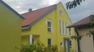 a yellow house with a red roof at Moderne großzügige Villa 246 qm 8,5 Zimmer, offener Kamin bis zu 13 Schlafplätze in Obergröningen