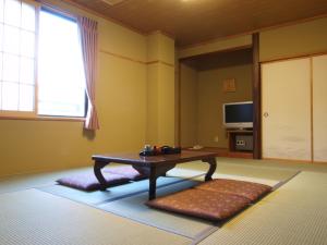 a living room with a coffee table and a window at Hakuba Hotel Hana-no-Sato in Hakuba