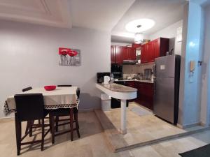 a kitchen with a table and a refrigerator at Blume Apartment Casa Port - 2 Bedrooms in Casablanca