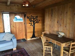 een kamer met een tafel en een boom aan de muur bij Sunrise Cabin et Sauna in Rothbach